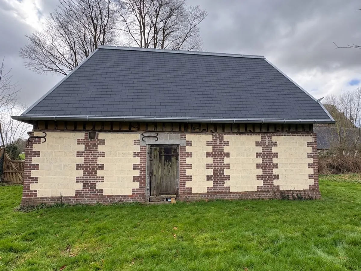 La même grange après réfection complète : ardoise neuve, faîtage et rives en zinc