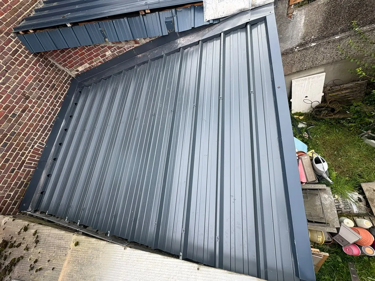 Grand pan de couverture en bac acier anthracite sur une annexe